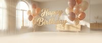 Elegant Happy Birthday golden text with beige and rose gold balloons in a bright, airy room, soft neutral tones for celebration cards and banners.