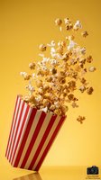Popcorn exploding from red striped container on yellow background for cinema entertainment and movie theater snack advertising.