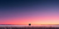 Two silhouettes walking together across vast field during stunning sunset with purple pink sky gradient creating romantic peaceful landscape scene.
