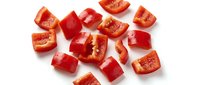 Fresh red tomato pieces chopped and diced on white background, isolated vegetable ingredient for cooking, salads and healthy recipes.