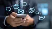 Glowing social media and messaging icons floating above smartphone held by business professional, depicting digital communication and mobile connectivity.