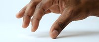 Mature male hand with medium skin tone gesturing downward on white surface, suitable for business presentations, tutorials, and instructional content.
