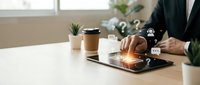 Professional businessman using digital tablet with glowing communication icons in modern office workspace for business technology and connectivity solutions.