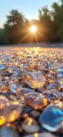Sunlight sparkles through melting ice crystals on frozen ground creating magical bokeh effect at sunset, nature abstract winter background with golden light reflections.