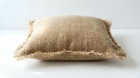 Rustic burlap throw pillow with fringe edges on a white background, isolated for home decor and interior design projects.