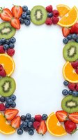 Fresh mixed fruit frame with strawberries, blueberries, kiwi, raspberries and orange slices on white background for healthy eating and nutrition concepts.