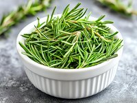 Fresh rosemary sprigs and leaves in white ceramic bowl on gray concrete background, aromatic Mediterranean herbs for cooking and seasoning food.