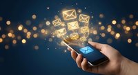 Hand holding smartphone with glowing email icons floating above screen against dark background with golden bokeh lights for digital communication concepts.