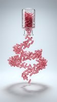 Red capsules spilling from glass bottle in dynamic motion on white background for pharmaceutical and healthcare design concepts.