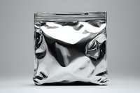 Metallic silver foil ziplock bag with wrinkles and reflective surface on neutral background, empty packaging mockup for product design and branding projects.