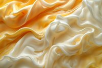 Luxurious white and golden silk fabric with soft waves and folds creating elegant abstract pattern. Smooth satin texture background for luxury design projects.