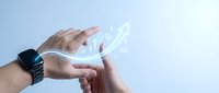 Hands holding smartphone with holographic digital interface projection displaying futuristic technology concepts for mobile app development and innovation.