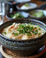 Creamy seafood chowder garnished with fresh chives in rustic ceramic bowl. Rich broth with shrimp and tender fish pieces creates appetizing comfort food presentation.