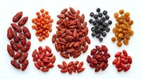 Assorted dried berries and goji fruits arranged in groups on white background, including red goji, orange sea buckthorn, and dark blueberries for healthy nutrition and wellness content.