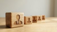 Wooden blocks with human silhouettes representing team leadership and business hierarchy concepts for corporate training materials.
