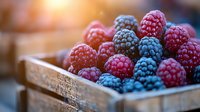 Fresh ripe red raspberries and blue blackberries in rustic wooden box with soft natural lighting, macro food photography for healthy eating concept.