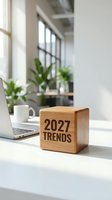 Wooden cube with 2027 trends text on modern office desk with laptop and coffee cup in bright workspace for business planning and forecasting concepts.