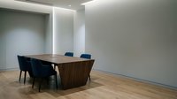 Modern minimalist conference room with wooden table and blue chairs in contemporary office space for business meetings and corporate presentations.