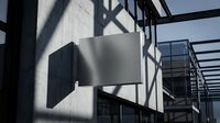 Modern blank signage mockup on concrete building exterior with dramatic shadows and industrial architecture for branding and advertising design projects.