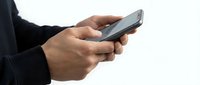 Man with dark skin tone holding and using smartphone on white background, isolated for business and technology design applications.