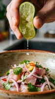 Hand squeezing fresh lime juice over ceviche with raw fish, red onion, cilantro and chili in ceramic bowl. Food preparation and cooking.