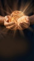 Hands of middle-aged male holding glowing golden orb with radiant light rays emanating outward against dark background. Suitable for spirituality, energy, magic, and mystical concepts.