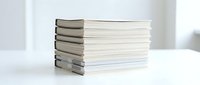 Stack of hardcover and paperback books arranged on white surface with neutral background, suitable for education, literature, publishing, and knowledge-related designs.