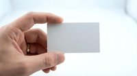 Male hand holding blank white business card mockup against light background for branding and corporate identity design projects.