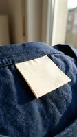 Blank canvas art board resting on cozy blue knit sweater in warm sunlit room ready for creative painting projects and artistic expression at home.