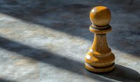 Wooden chess pawn piece casting dramatic shadow on textured surface, highlighting strategy and leadership concepts in business and game settings.