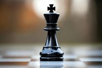 Black king chess piece standing alone on chessboard with soft blurred background, dramatic lighting highlights strategic game piece in macro photography.