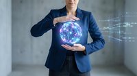 Professional businesswoman in navy suit protecting glowing digital globe with hands representing global business technology and data security concepts.