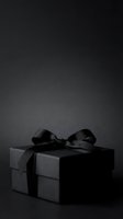 Elegant black gift box with satin ribbon bow on dark background, suitable for luxury product packaging, holiday promotions, and celebration designs.