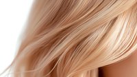 Soft flowing blonde hair strands in gentle motion against light background, showcasing natural shine and smooth texture for beauty and haircare advertising.