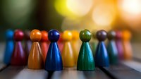 Colorful wooden game pieces lined up in row against blurred bokeh background, showing diversity and teamwork concept. Macro photography with selective focus.