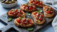 Toasted bread slices topped with diced tomatoes, garlic, basil and olive oil served as appetizers or bruschetta for entertaining and dining occasions.