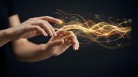 Hands releasing glowing golden energy waves and particles against dark background, representing magic, power, innovation, technology, and creative potential for design projects.