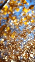 Magical golden and blue bokeh background with glowing particles and sparkles creating dreamy abstract pattern for festive designs and celebrations.