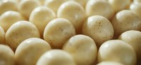 Fresh white mushrooms with speckled caps in close-up view, showcasing organic texture and natural pattern for food photography and culinary use.