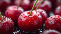 Fresh ripe red cherries with water drops and green stems on dark background, macro shot showing juicy texture and natural freshness of summer fruit.