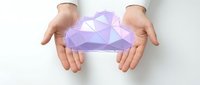 Hands protecting purple geometric crystal shape symbolizing care, security and valuable asset protection for business and insurance concepts.