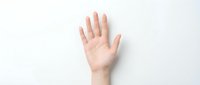 Open palm of a light-skinned hand raised against a neutral white background, suitable for concepts of stop, halt, refusal, permission, greeting, or traffic control signage.