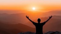 Man with raised arms celebrating success at mountain summit during golden sunrise with layered peaks creating inspirational freedom and achievement moment.