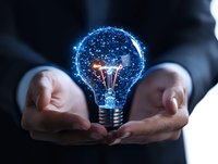 Business professional holding glowing light bulb with blue digital network effect, symbolizing innovation and creative technology solutions in corporate setting.
