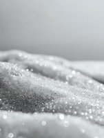 Sparkling frost crystals create abstract winter landscape in black and white macro photography, with soft bokeh effect and delicate light reflections on icy surface.
