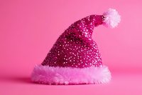 Glittery magenta Santa hat with fluffy pink trim and pom-pom on solid pink background, isolated for holiday designs and festive decorations.