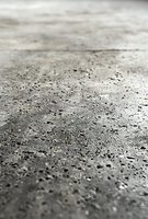 Raindrops on gray metallic surface create abstract pattern with shallow depth of field. Water beads reflect light against dark background, showing natural minimalism.