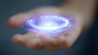 Glowing spiral galaxy hologram floating above open palm against dark background, magical purple and blue light effects create mystical atmosphere.
