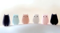 Cute minimalist cat silhouettes in pastel colors and black on light background, simple kawaii style characters for children's design and decoration.