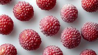 Fresh ripe raspberries scattered on white background, macro shot with soft shadows showing detailed texture and natural pattern of berries isolated for food design.